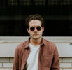 man standing in front of white concrete wall